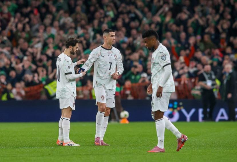 Portugal's forward Cristiano Ronaldo hands the captain's armband to Portugal's midfielder Bernardo Silva (L) as he leaves the pitch after receiving a second yellow card during the men's football 2026 World Cup Group F qualifier between Ireland and Portugal at Aviva Stadium in Dublin on November 13, 2025. Paul Faith / AFP