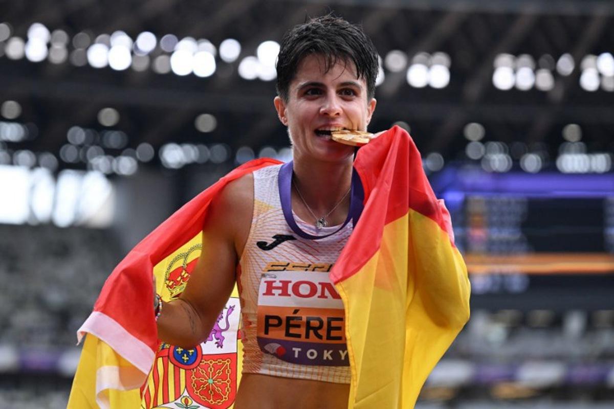 Gold medallist Spain's athlete Maria Perez celebrates with her medal and her country's flag winning the women's 20km race walk final during the World Athletics Championships in Tokyo on September 20, 2025. Jewel SAMAD / AFP