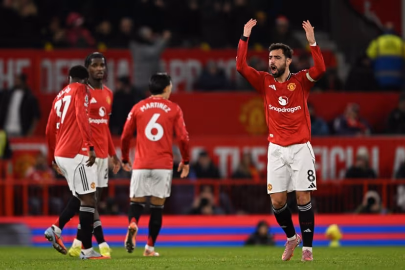 Manchester United's Portuguese midfielder #08 Bruno Fernandes gestures to the crowd as he celebrates scoring their third goal to equalise 3-3 during the English Premier League football match between Manchester United and Bournemouth at Old Trafford in Manchester, north west England, on December 15, 2025. PETER POWELL / AFP