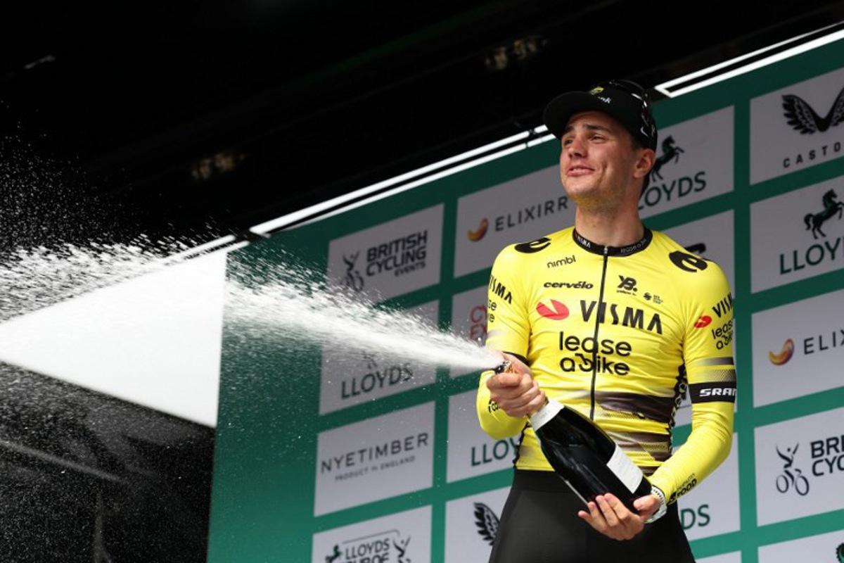 Team Visma Lease a Bike's Dutch rider Olav Kooij sprays the champagne on the podium as he celebrates winning the sixth stage of the Tour of Britain cycling race, in Cardiff on September 7, 2025. Darren Staples / AFP