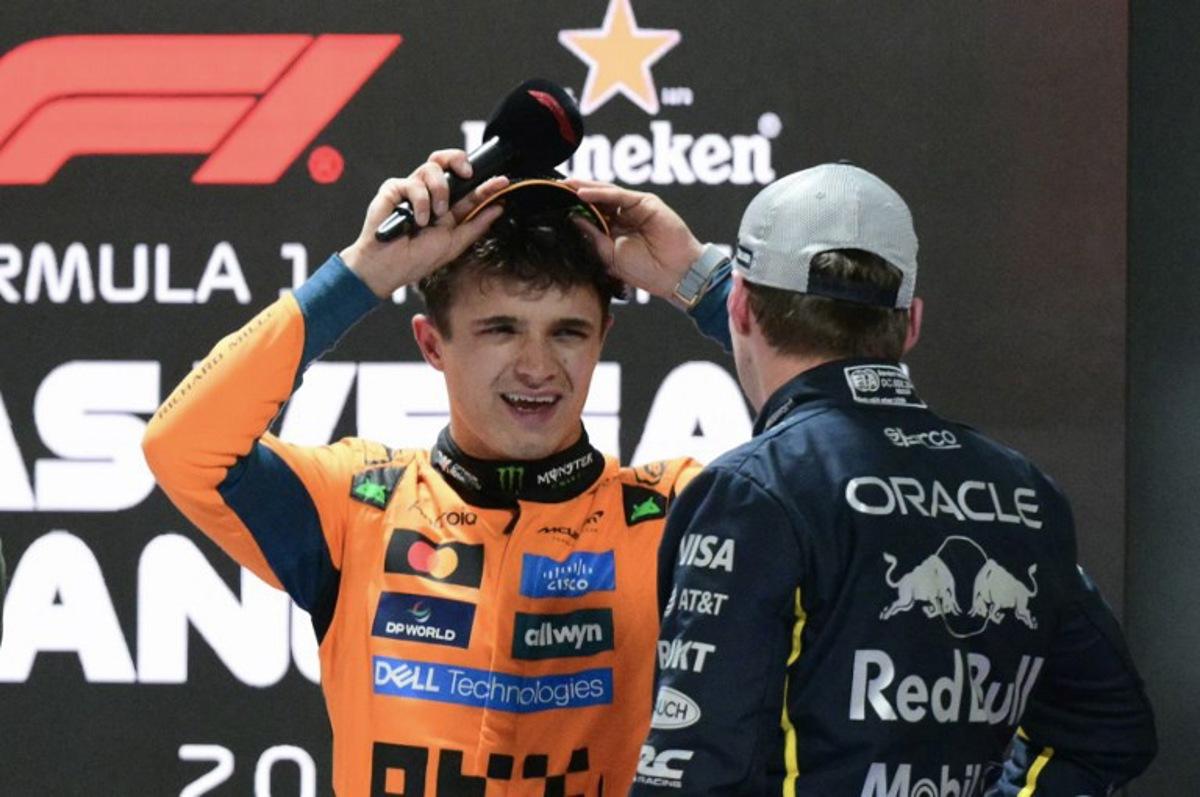 (L/R) Pole position winner McLaren's British driver Lando Norris speaks to 2nd place finisher Red Bull Racing's Dutch driver Max Verstappen after the qualifying session for the Las Vegas Formula One Grand Prix at the Las Vegas Strip Circuit in Las Vegas, Nevada, on November 21, 2 025. Frederic J. Brown / AFP