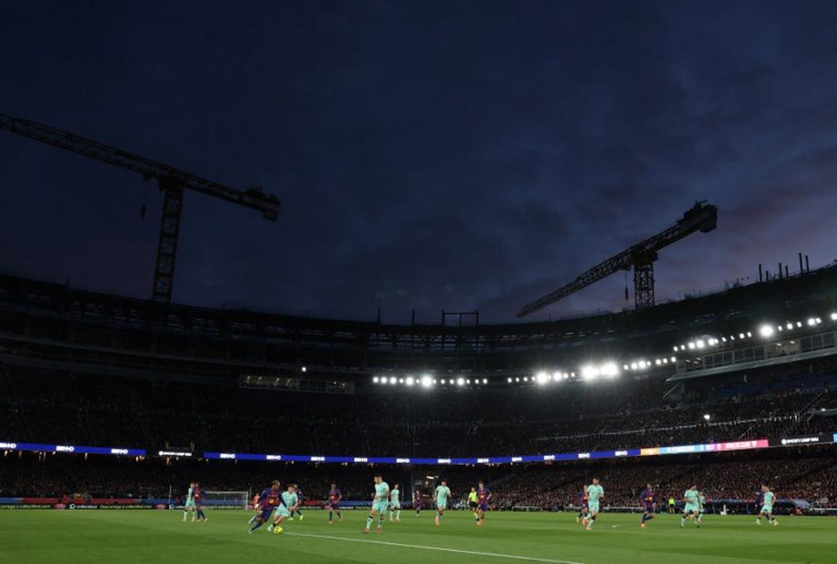 A picture taken on November 22, 2025 shows cranes in background during the Spanish league football match between FC Barcelona and Athletic Club Bilbao at Camp Nou Stadium in Barcelona, still partially under construction. Lluis GENE / AFP