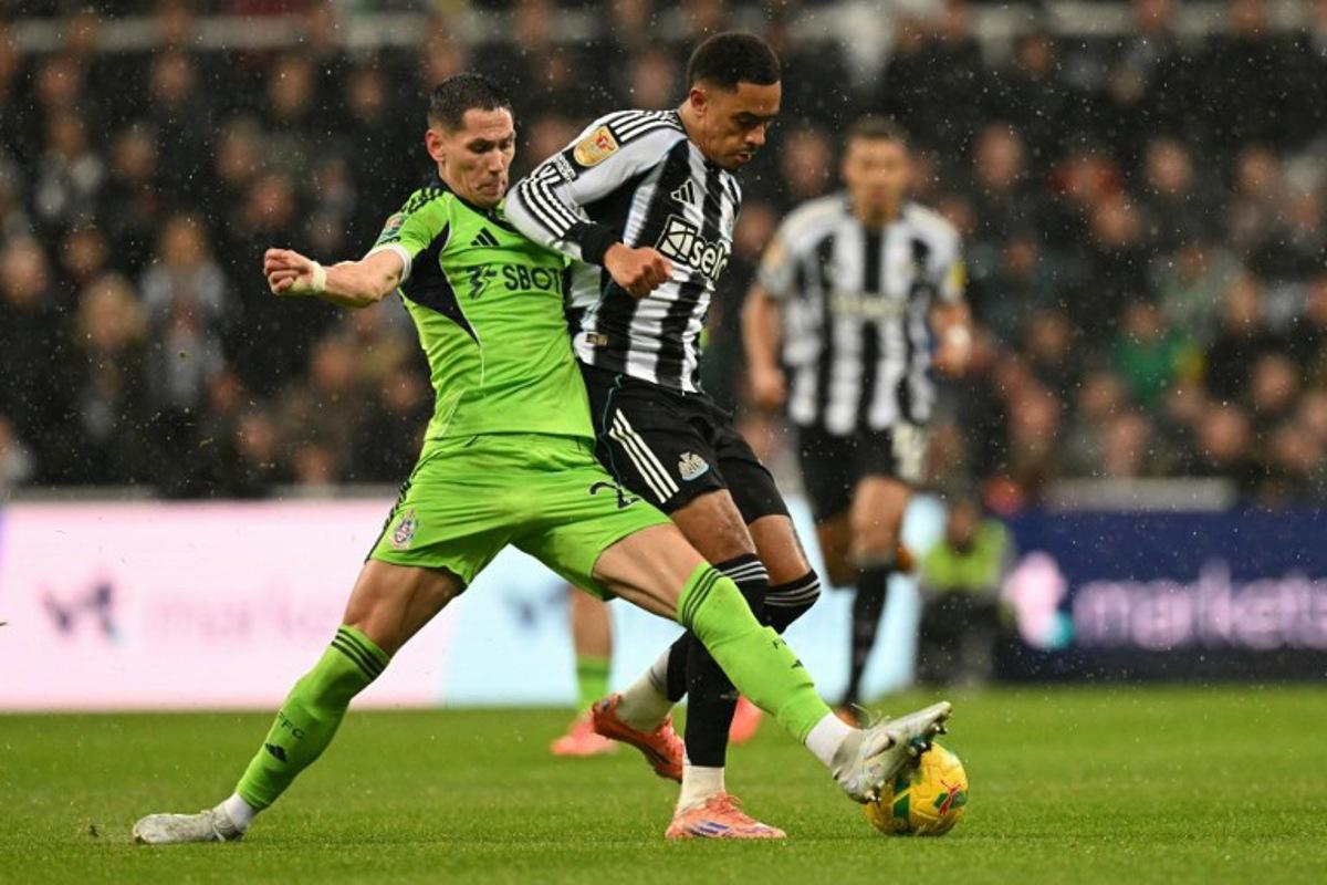 Fulham's Serbian midfielder #20 Sasa Lukic (L) tackles Newcastle United's English midfielder #41 Jacob Ramsey (R) during the English League Cup quarter-final football match between Newcastle United and Fulham at St James' Park in Newcastle-upon-Tyne, north east England on December 17, 2025. Oli SCARFF / AFP