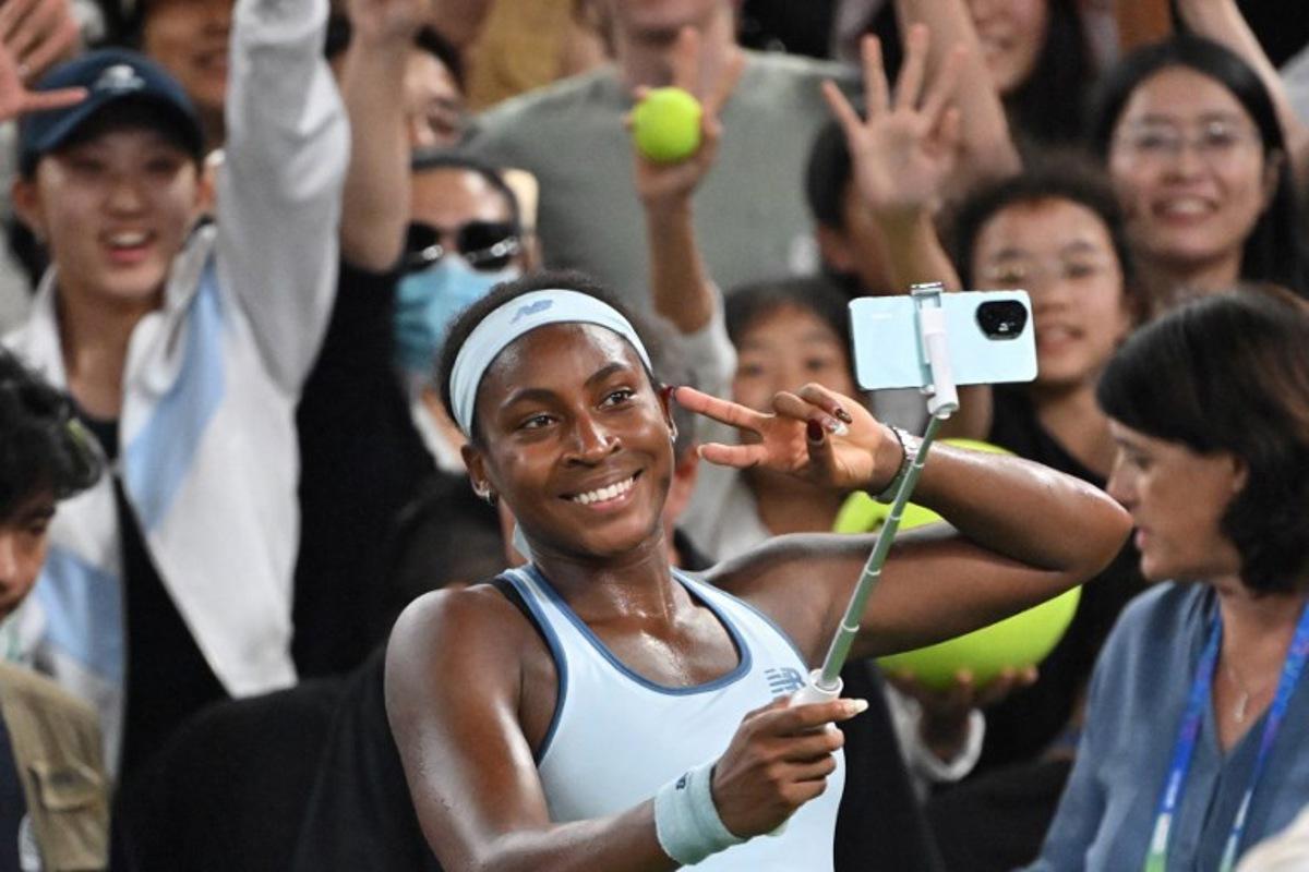 USA's Coco Gauff takes a selfie with fans after winning against Italy's Jasmine Paolini in their women's singles semi-final match at the Wuhan Open tennis tournament in Wuhan, Central China's Hubei province on October 11, 2025. ADEK BERRY / AFP