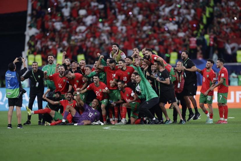 Morocco's players and staff pose for a photograph as they celebrate their win during the FIFA Arab Cup 2025 semi-final football match between Morocco and the United Arab Emirates at the Khalifa International Stadium in Al-Rayyan on December 15, 2025. KARIM JAAFAR / AFP