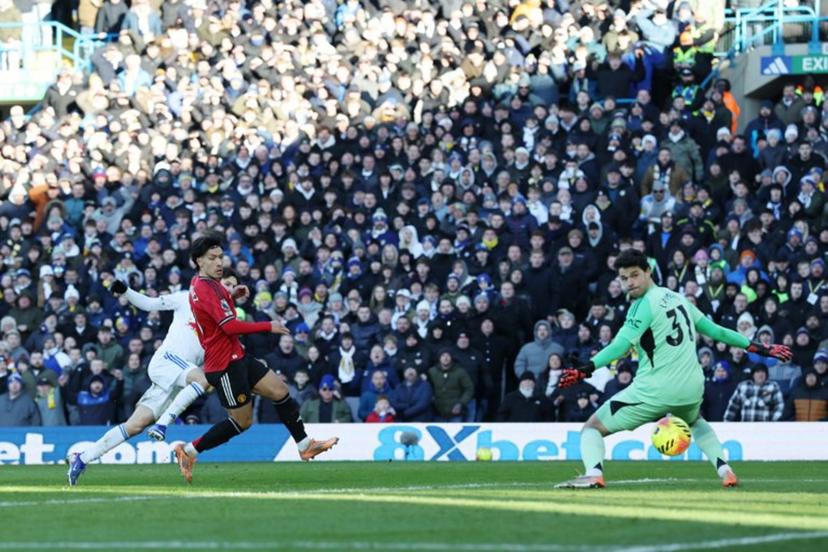 Leeds United's US midfielder #11 Brenden Aaronson (L) scores the opening goal past Manchester United's Belgian goalkeeper #31 Senne Lammens (R) to take the lead 1-0 during the English Premier League football match between Leeds United and Manchester United at Elland Road in Leeds, northern England on January 4, 2026. Darren Staples / AFP