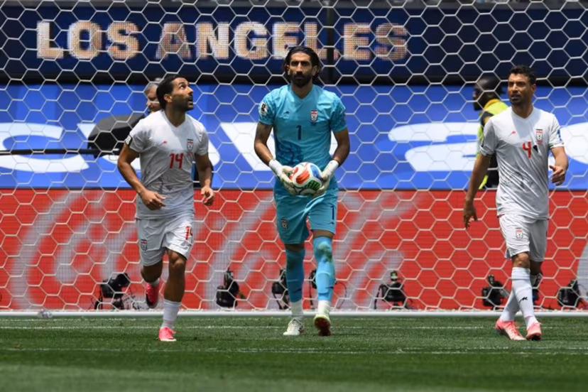 Iran's goalkeeper #01 Alireza Beiranvand holds the ball next to teammates midfielder #14 Saman Ghoddos and defender #04 Shojae Khalilzadeh during the 2026 World Cup Group G football match between Belgium and Iran at the Los Angeles Stadium in Inglewood on June 21, 2026. Patrick T. Fallon / AFP