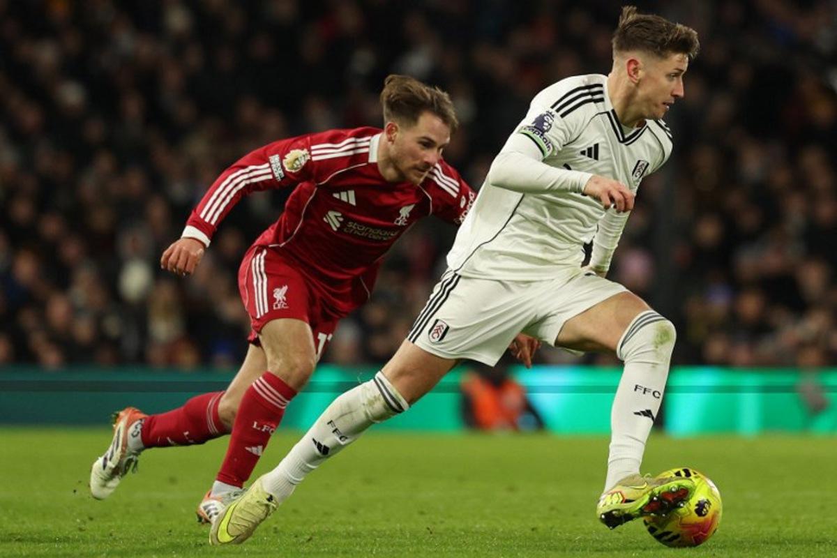 Fulham's English midfielder #10 Tom Cairney (R) takes on Liverpool's Argentinian midfielder #10 Alexis Mac Allister (L) during the English Premier League football match between Fulham and Liverpool at Craven Cottage in London on January 4, 2026. Adrian Dennis / AFP