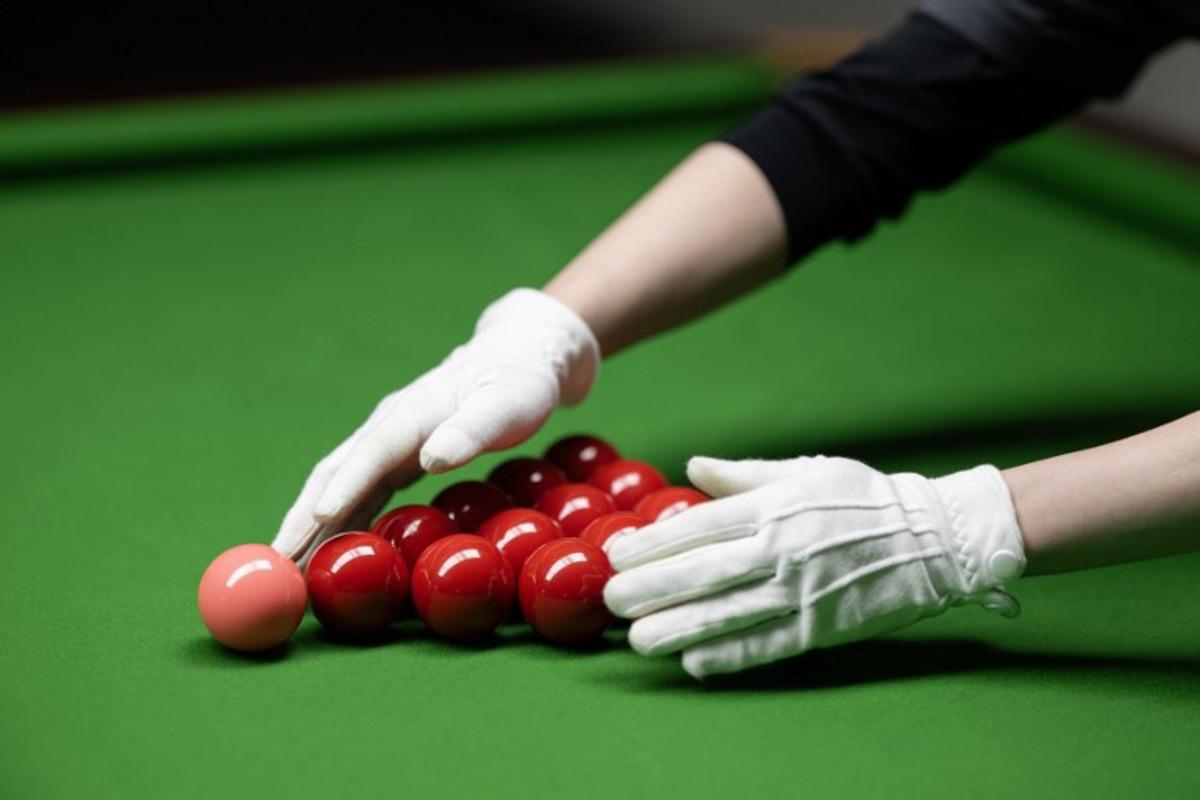 Cody Liu racks snooker balls for his son, the Hong Kong born snooker player Shaun Liu, aged 15, as he practices in the Ding Junhui Snooker Academy in the centre of Sheffield, northern England on September 10, 2025. Since 1977 the Snooker World Championship has been held every year in Sheffield's 980-seat Crucible Theatre, with an estimated 500 million spectators watching the televised broadcast across 150 countries. China's Zhao Xintong is the reigning World Snooker Champion, the first Asian player to win the title, whilst China's Bai Yulu is the reigning winner of the World Women's Snooker Championship. Snooker remains incredibly popular in China, with around 50 million people playing the game and approximately 300,000 snooker clubs, however many professional Chinese players are based in Sheffield, England as the widely-acknowledged home of the sport. Oli SCARFF / AFP