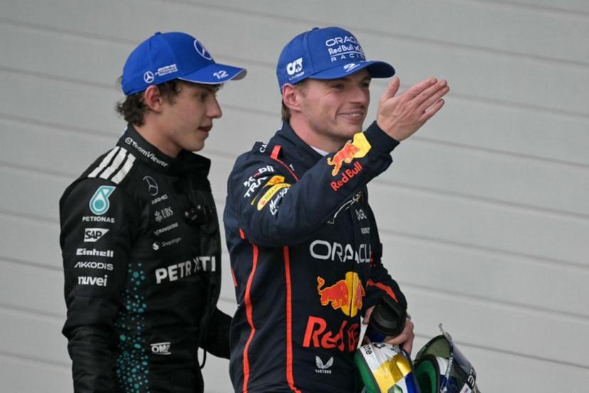 Red Bull Racing's Dutch driver Max Verstappen (R) smiles as he blows a kiss, next to Mercedes' Italian driver Kimi Antonelli (L), after getting the third place during the Sao Paulo Formula One Grand Prix at the Jose Carlos Pace racetrack, aka Interlagos, in Sao Paulo, Brazil on November 9, 2025. Nelson ALMEIDA / AFP