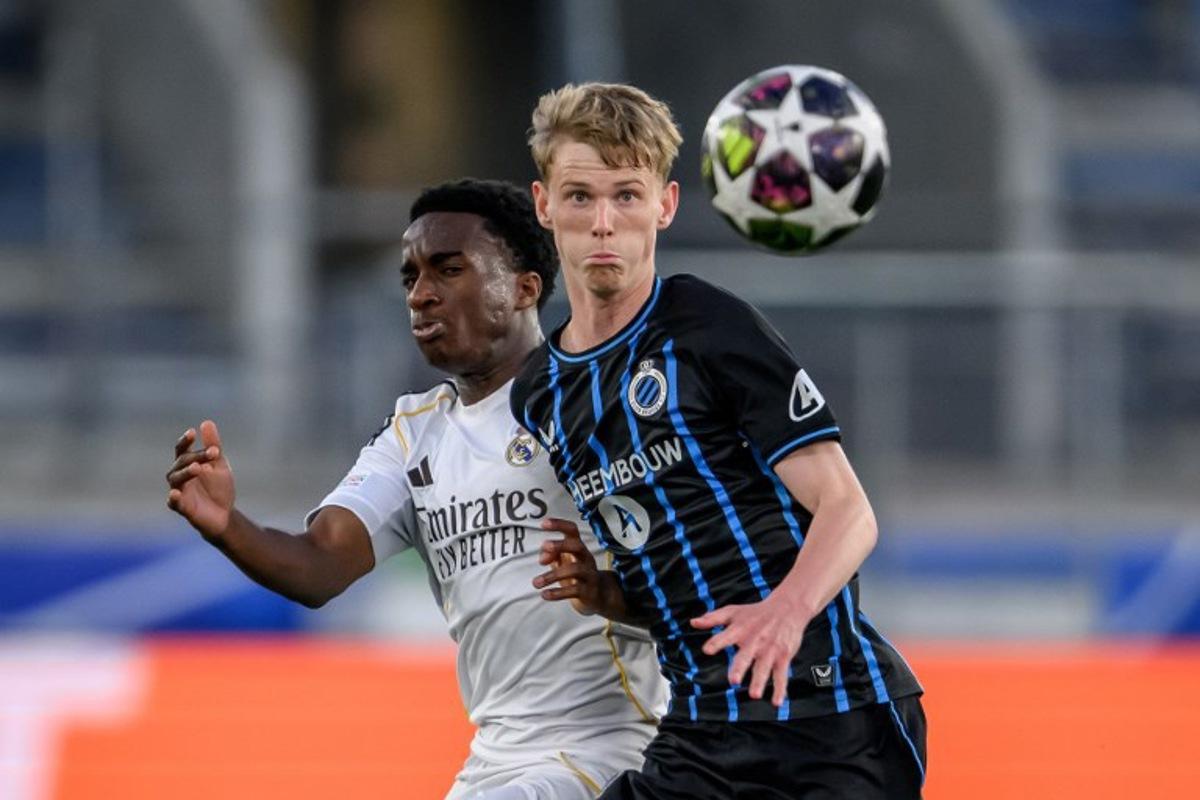 Club Brugge's Danish midfielder #78 Tobias Lund Jensen (R) eyes the ball next to Real Madrid's Spanish defender #12 Melvin Ukpeigbe during the UEFA Youth League final football match between Club Brugge and Real Madrid at Stade de la Tuiliere in Lausanne, on April 20, 2026. Fabrice COFFRINI / AFP