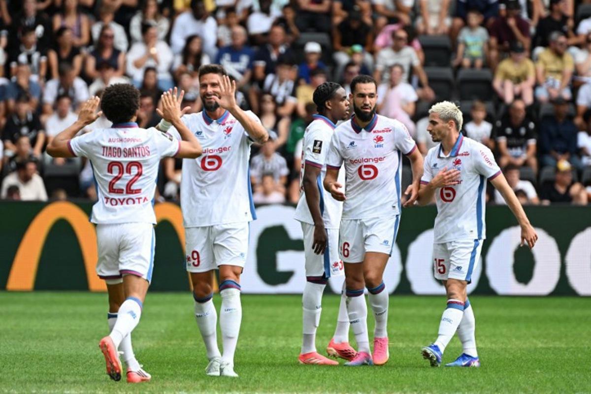 Lille's Portuguese defender #22 Tiago Santos (L) celebrates with teammates after scoring his team's first goal during the French L1 football match between Angers SCO and LOSC Lille at the Stade Raymond Kopa in Angers, western France on August 23, 2026. Sebastien Salom-Gomis / AFP