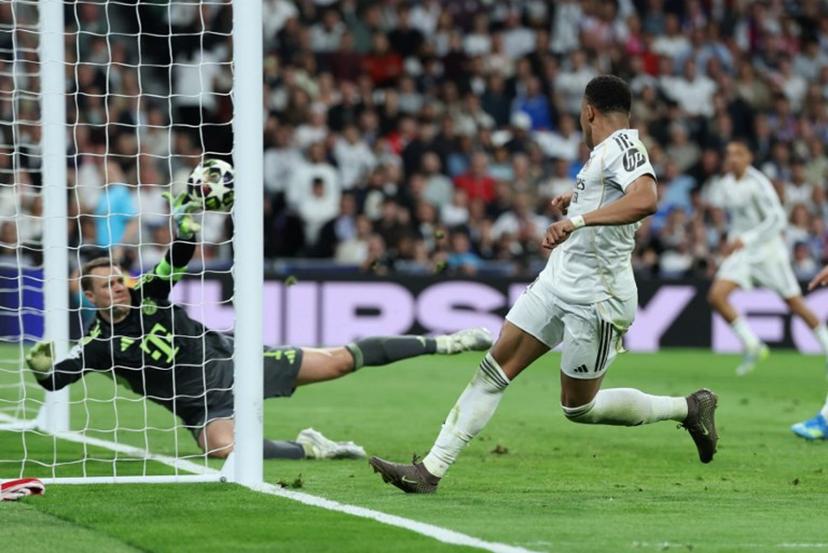 Real Madrid's French forward #10 Kylian Mbappe scores his team's first goal during the UEFA Champions League quarter final first leg football match between Real Madrid CF and FC Bayern Munich at Santiago Bernabeu Stadium in Madrid on April 7, 2026. Thomas COEX / AFP