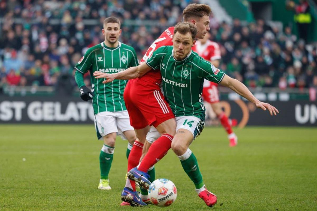 Bremen's Belgian midfielder #14 Senne Lynen and Bayern Munich's German midfielder #06 Joshua Kimmich vie for the ball during the German first division Bundesliga football match between SV Werder Bremen and FC Bayern Munich in Bremen, northern Germany February 14, 2026. Focke Strangmann / AFP