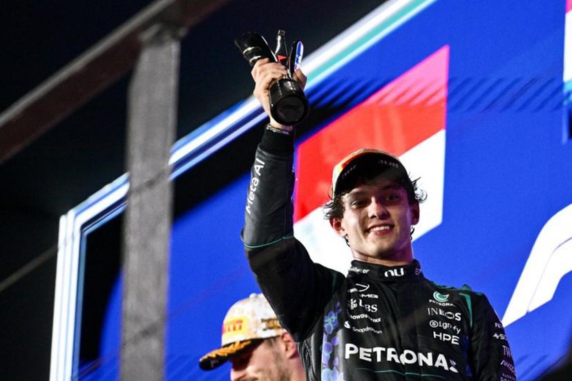 Third-placed Mercedes' Italian driver Kimi Antonelli lifts his trophy as he celebrates on the podium after the Formula One Singapore Grand Prix at the Marina Bay Street Circuit in Singapore on October 11, 2026. ANTHONY WALLACE / AFP