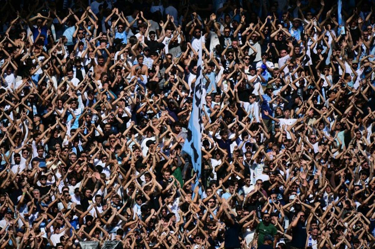 Lazio's supporters cheer their team during the Italian Serie A football match between Lazio and Roma at the Olympic stadium in Rome, on September 21, 2025. Tiziana FABI / AFP