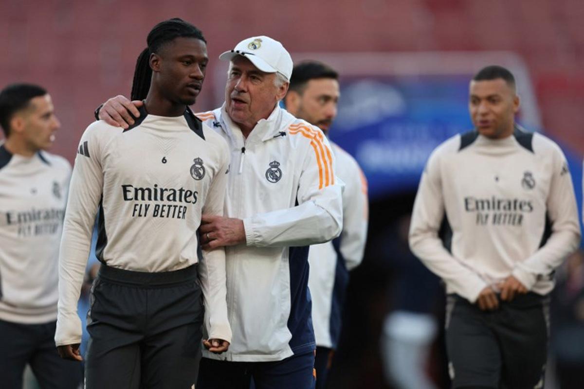 Real Madrid's Italian coach Carlo Ancelotti (C) speaks with Real Madrid's French midfielder #06 Eduardo Camavinga (L) during a training session at the Emirates stadium in London on April 7, 2025, on the eve of their UEFA Champions League Quarter final first leg football match against Arsenal. Adrian Dennis / AFP