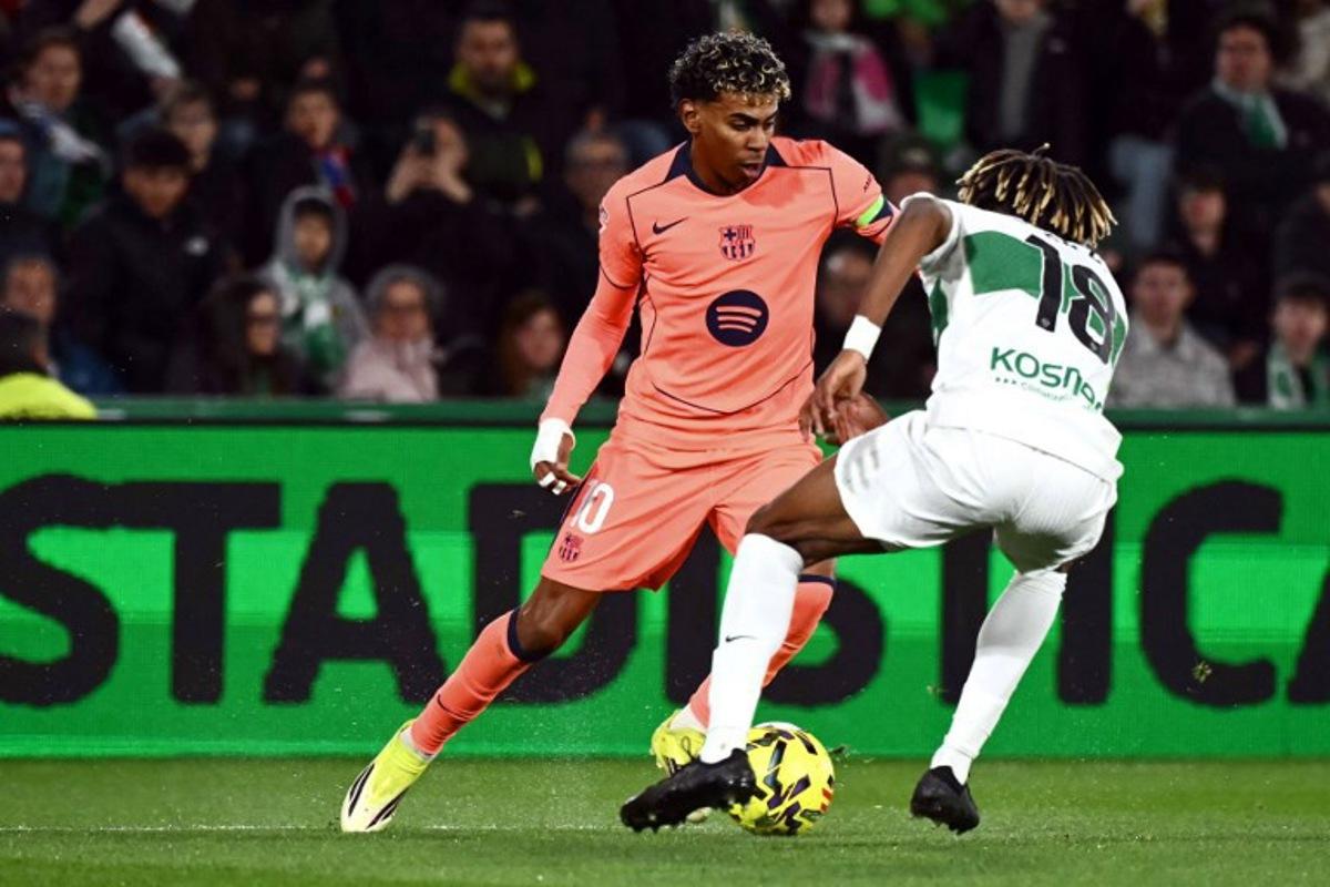 Barcelona's Spanish forward #10 Lamine Yamal and Elche's Spanish defender #18 John Donald fight for the ball during the Spanish league football match between Elche CF and FC Barcelona at thge Martinez Valero stadium in Elche on January 31, 2026. JOSE JORDAN / AFP