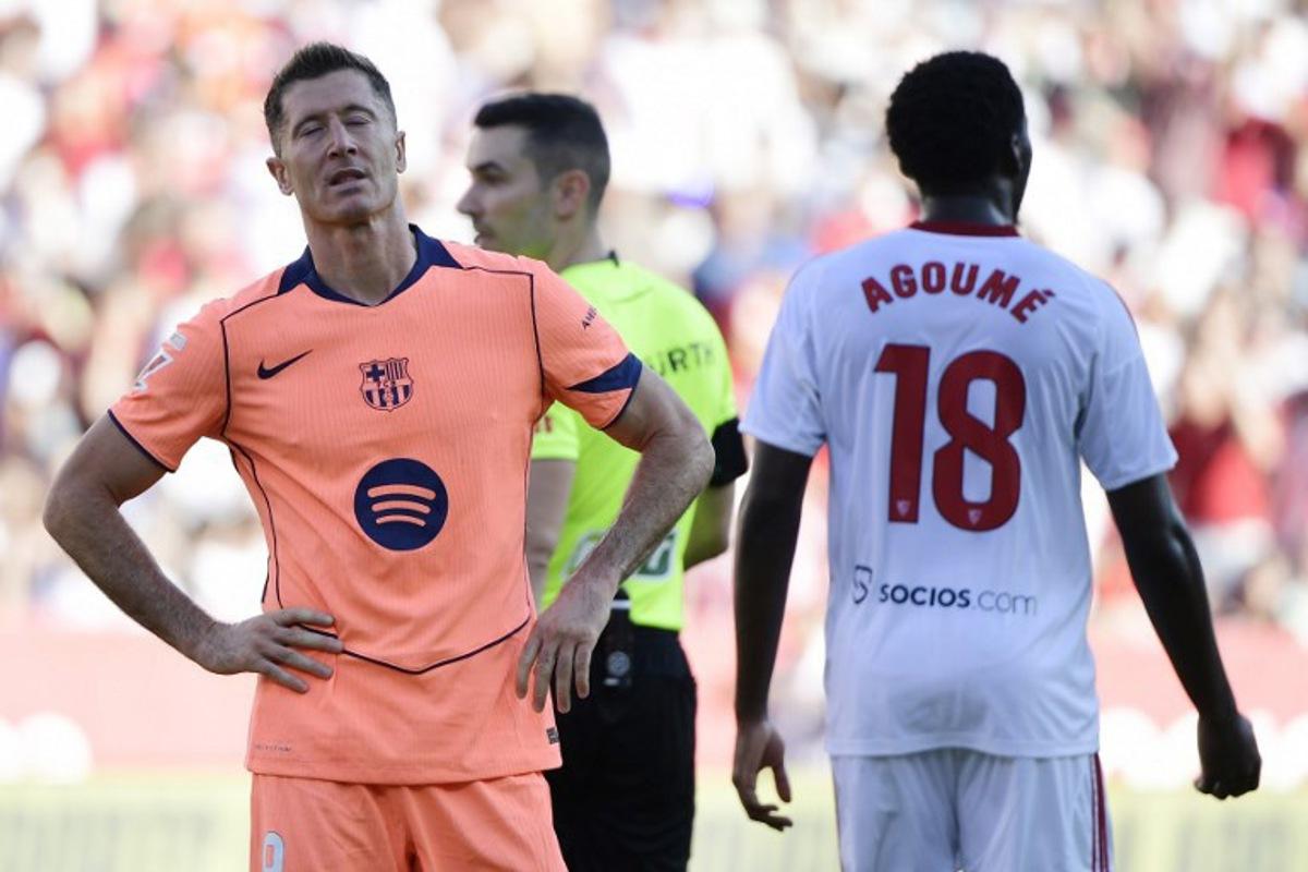 Barcelona's Polish forward #09 Robert Lewandowski (L) reacts to missing a penalty kick during the Spanish league football match between Sevilla FC and FC Barcelona at Ramon Sanchez Pizjuan Stadium in Seville on October 5, 2025. CRISTINA QUICLER / AFP
