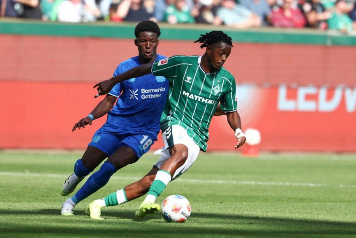 Bayer Leverkusen's French defender #16 Axel Tape (L) and Bremen's Belgian midfielder #07 Samuel Mbangula vie for the ball during the German first division Bundesliga football match between Werder Bremen and Bayer Leverkusen in Bremen on August 30, 2025. Ibrahim OT / AFP