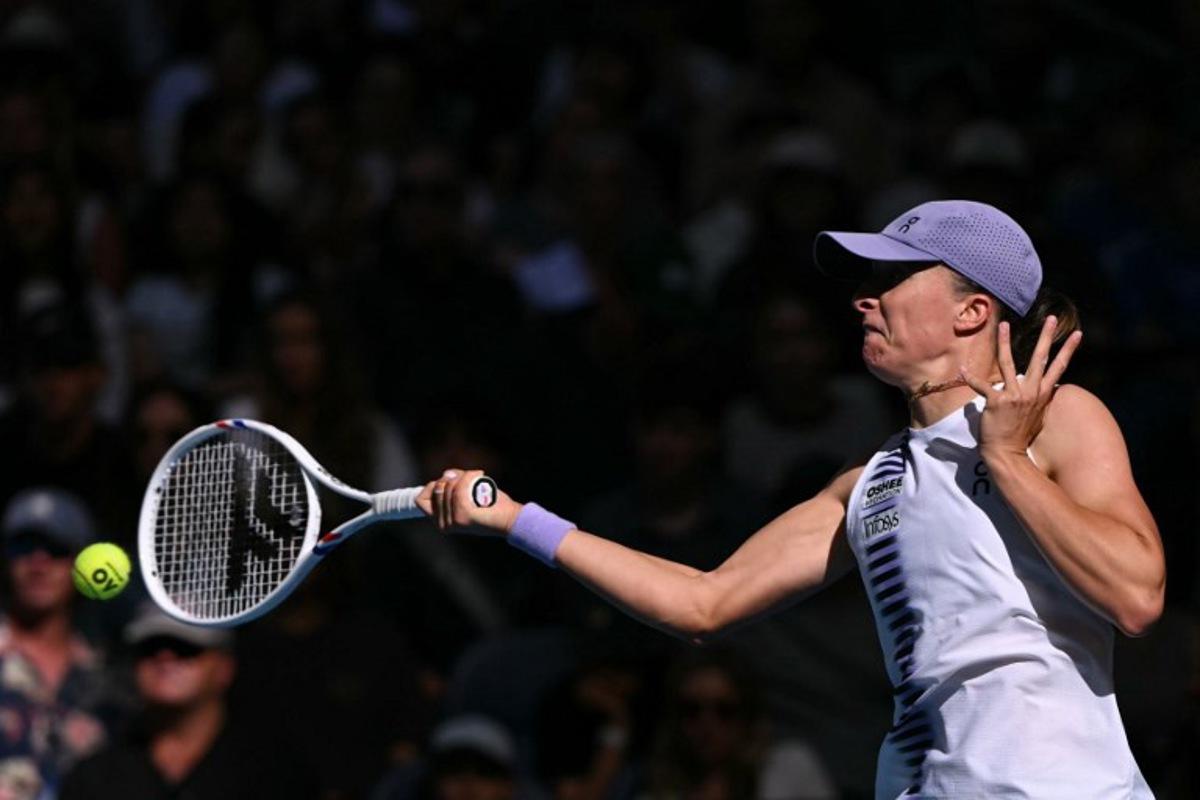 Poland's Iga Swiatek hits a return to Czech Republic's Marie Bouzkova during their women's singles match on day five of the Australian Open tennis tournament in Melbourne on January 22, 2026. WILLIAM WEST / AFP