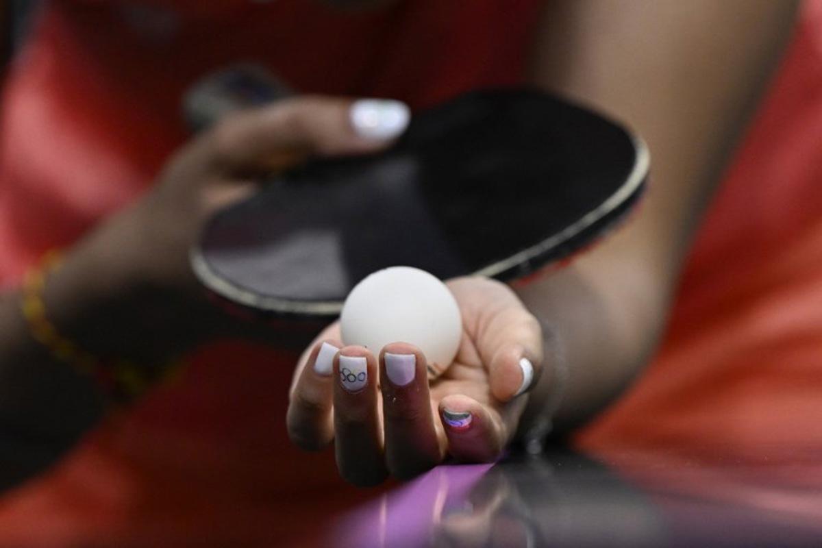 A detailed view of India's Manika Batra's nails painted with the Indian flag and Olympic Rings as she prepares to serve the ball during her women's table tennis singles match in the team quarter-finals between India and Germany at the Paris 2024 Olympic Games at the South Paris Arena in Paris on August 7, 2024. WANG Zhao / AFP