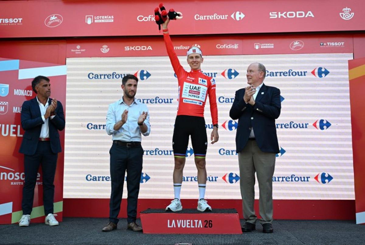 UAE Team Emirates - XRG team's Slovenian rider Tadej Pogacar celebrates on the podium wearing the overall leader's red jersey flanked by (from R) Prince's Albert II of Monaco, Manosque's mayor Camille Galtier and Spanish former Tour de France winner Oscar Pereiro after the second stage of the Vuelta a Espana 2026, a 214,3 km race between Monaco and Manosque on August 23, 2026. Miguel MEDINA / AFP