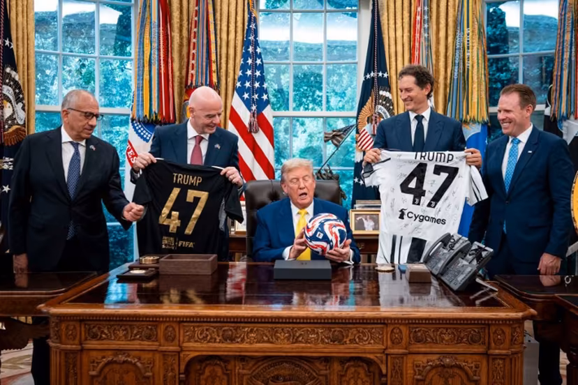US President Donald Trump (C) flanked by (L/R) Carlos Cordeiro, former president of the United States Soccer Federation, FIFA President Gianni Infantino, Chairperson of Ferrari John Elkann and Executive Director of the presidential task force for the 2026 FIFA World Cup Andrew Giuliani, holds a ball as he makes remarks in the Oval Office of the White House during a visit by members of Italian soccer club Juventus in Washington, DC, on June 18, 2025. Juventus will play Emirati club Al-Ain in the 2025 FIFA Club World Cup at Washington's Audi Field later in the day. Doug Mills / POOL / AFP