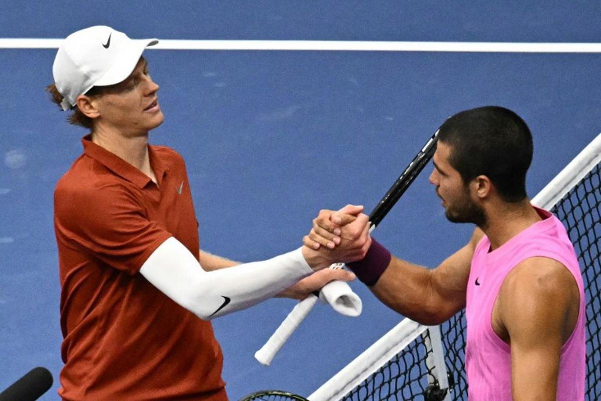 Italy's Jannik Sinner (L) and Spain's Carlos Alcaraz shake hands at the net after alcaraz won the men's singles final tennis match on day fifteen of the US Open tennis tournament at the USTA Billie Jean King National Tennis Center in New York City on September 7, 2025. Mandel NGAN / AFP