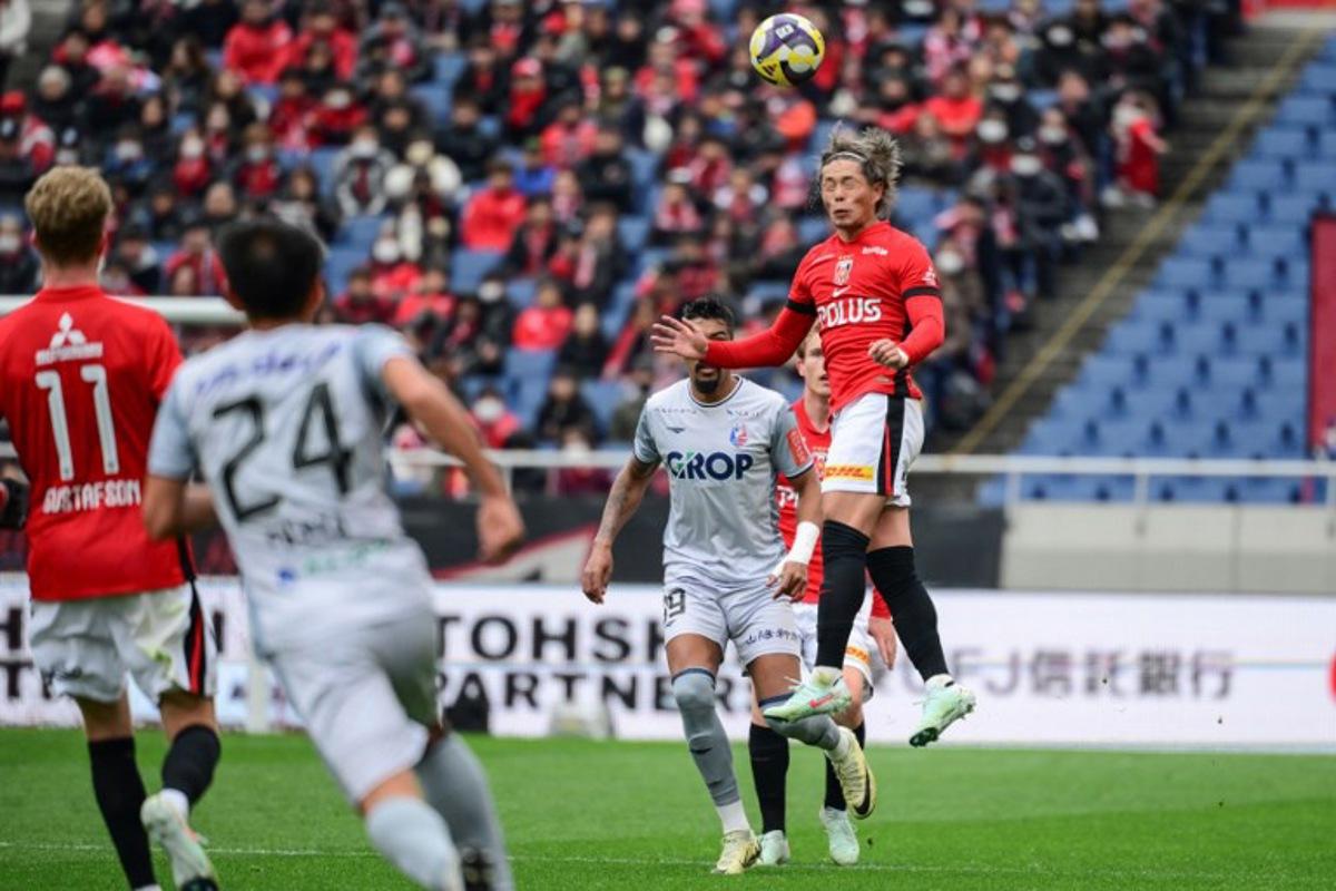 Urawa's forward Takuya Ogiwara (R) heads the ball during the J-League football match between Urawa Red Diamonds and Fagiano Okayama at Saitama stadium 2002 in Saitama city on March 8, 2025. Yuichi YAMAZAKI / AFP