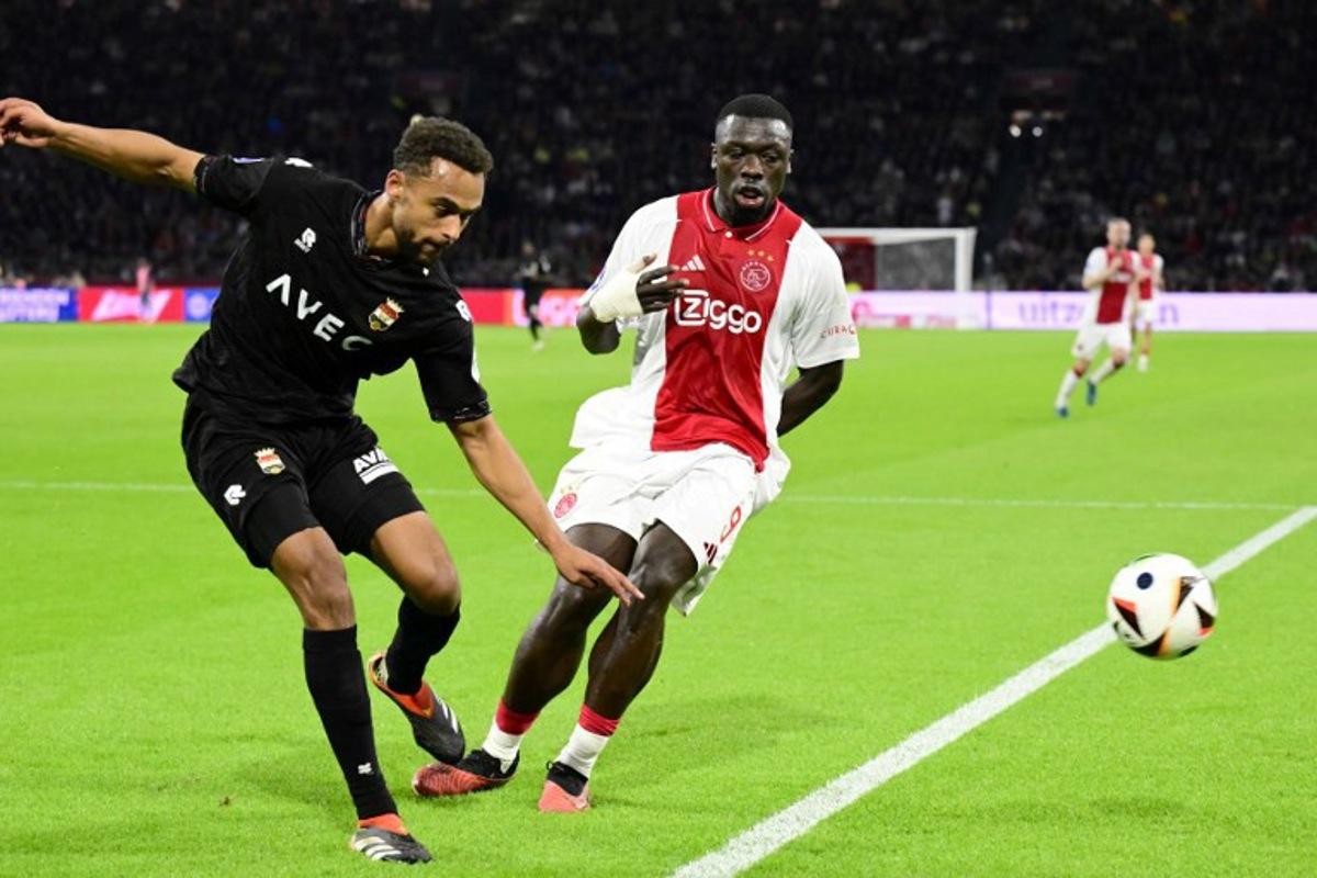 Willem II's Dutch defender #33 Tommy St. Jago (L) fights for the ball with Ajax's Dutch forward #09 Brian Brobbey (C) during the Dutch Eredivisie match between Ajax Amsterdam and Willem II at the Johan Cruyff Arena, in Amsterdam, on October 27, 2024. Olaf Kraak / ANP / AFP
