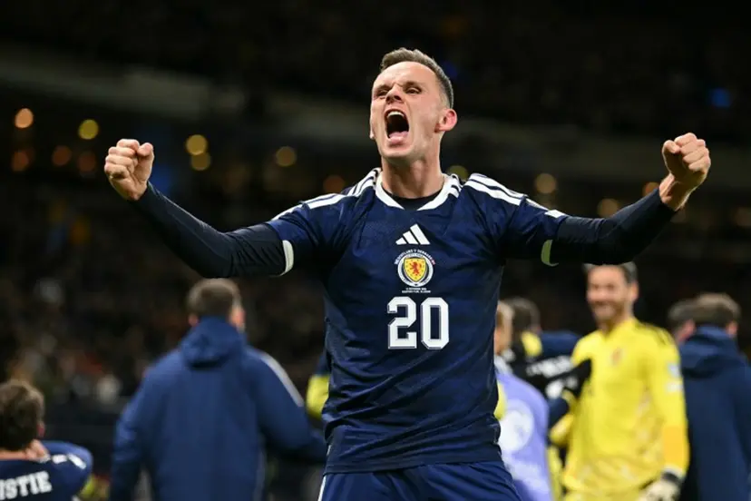 Scotland's striker #20 Lawrence Shankland celebrates on the pitch after the FIFA World Cup 2026 European qualification football match between Scotland and Denmark at Hampden Park in Glasgow on November 18, 2025. Scotland scored two dramatic stoppage-time goals to beat 10-man Denmark 4-2 on Tuesday and reach the World Cup for the first time since 1998. ANDY BUCHANAN / AFP