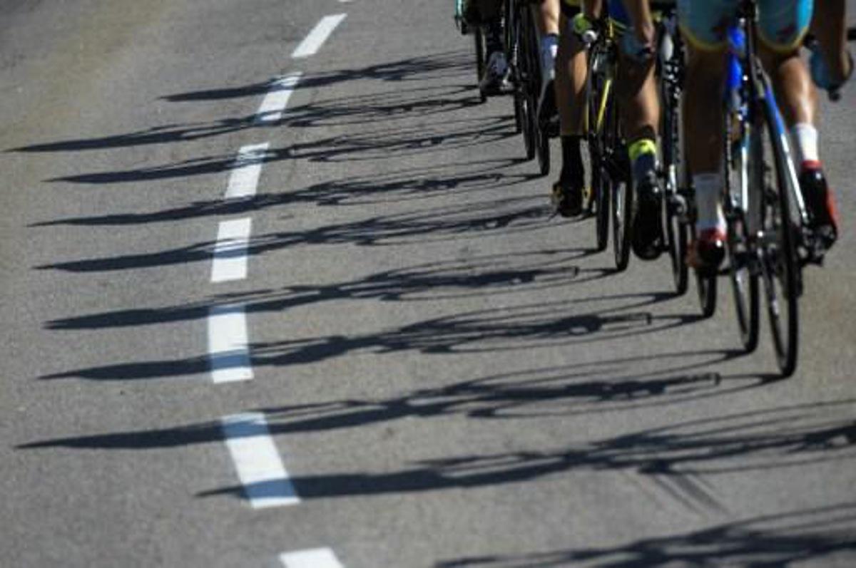 Shadows of wheels are pictured during the 186,5 km eighteenth stage of the 102nd edition of the Tour de France cycling race on July 23, 2015, between Gap and Saint-Jean-de-Maurienne, French Alps. AFP PHOTO / LIONEL BONAVENTURE