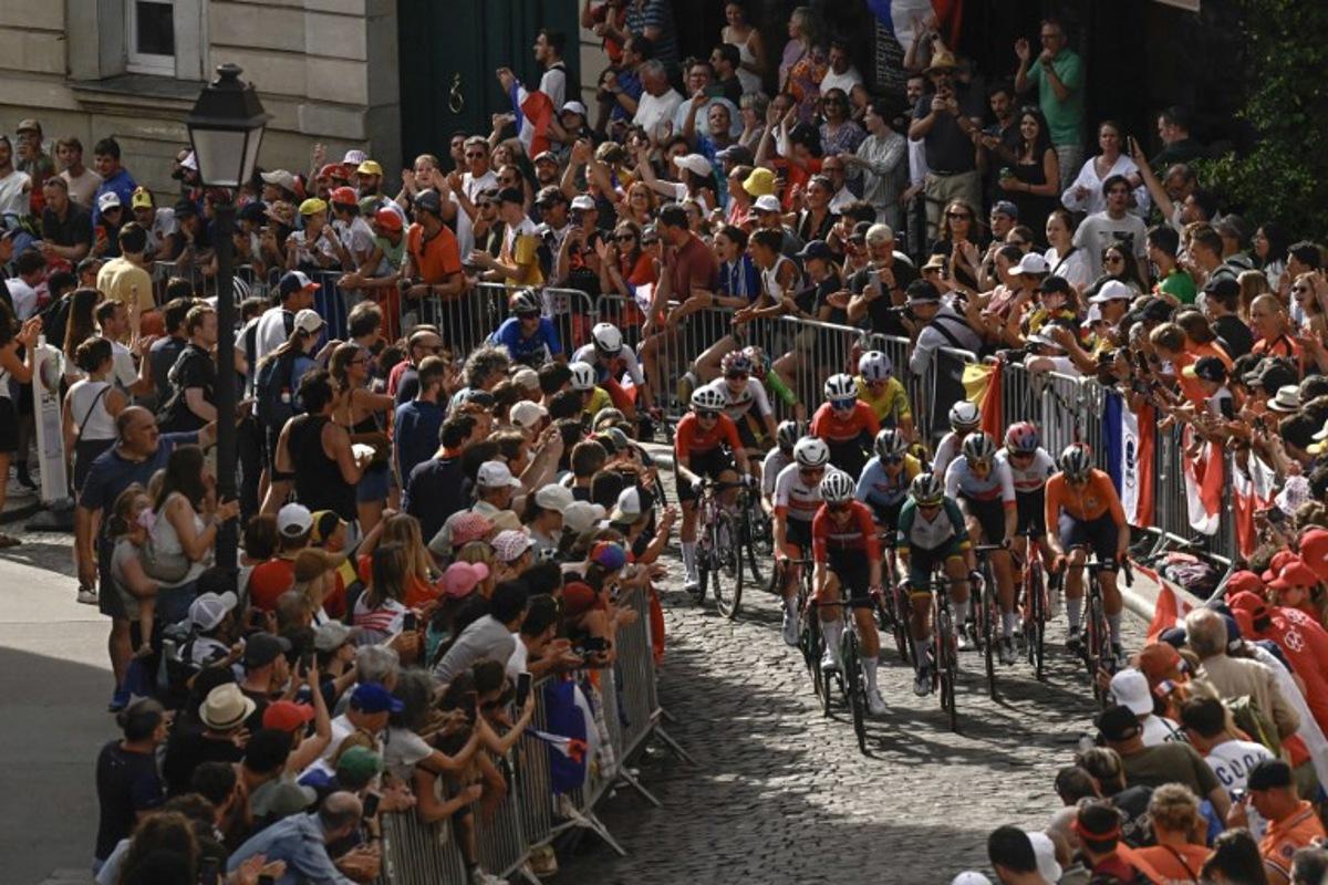 The pack of riders (peloton) cycles in the ascent of Rue Lepic on the Butte de Montmartre during the women's cycling road race during the Paris 2024 Olympic Games in Paris, on August 4, 2024. JULIEN DE ROSA / AFP