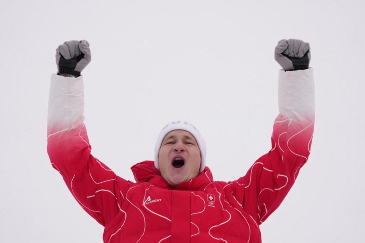Silver medallist Switzerland's Marco Odermatt celebrates on the podium of the men's giant slalom alpine skiing event during the Milano Cortina 2026 Winter Olympic Games at the Stelvio Ski Centre in Bormio (Valtellina) on February 14, 2026. Dimitar DILKOFF / AFP