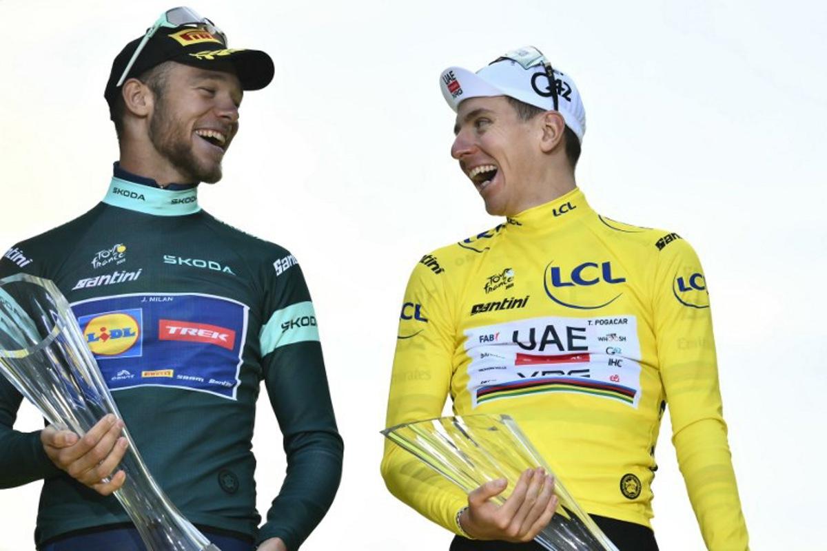 UAE Team Emirates - XRG team's Slovenian rider Tadej Pogacar wearing the overall leader's yellow jersey (R) shakes a laugh with Lidl - Trek team's Italian rider Jonathan Milan wearing the best sprinter's green jersey on the podium after the 21st and final stage of the 112th edition of the Tour de France cycling race, 132.3 km between Mantes-la-Ville and Paris Champs-Élysees, on July 27, 2025. Marco BERTORELLO / AFP
