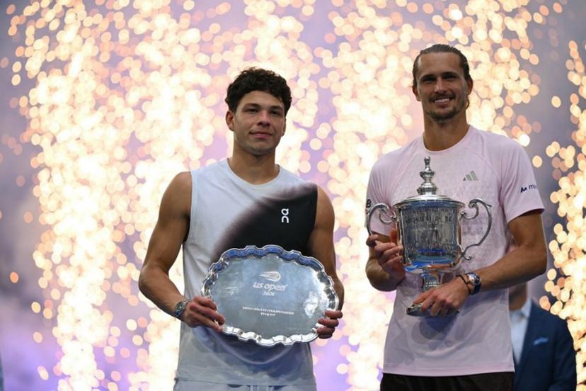 USA's Ben Shelton holds the runner-up trophy next to Germany's Alexander Zverev who holds the winner's trophy after the men's singles final tennis match on day fifteen of the US Open tennis tournament at the USTA Billie Jean King National Tennis Center in New York City on September 13, 2026. ANGELA WEISS / AFP