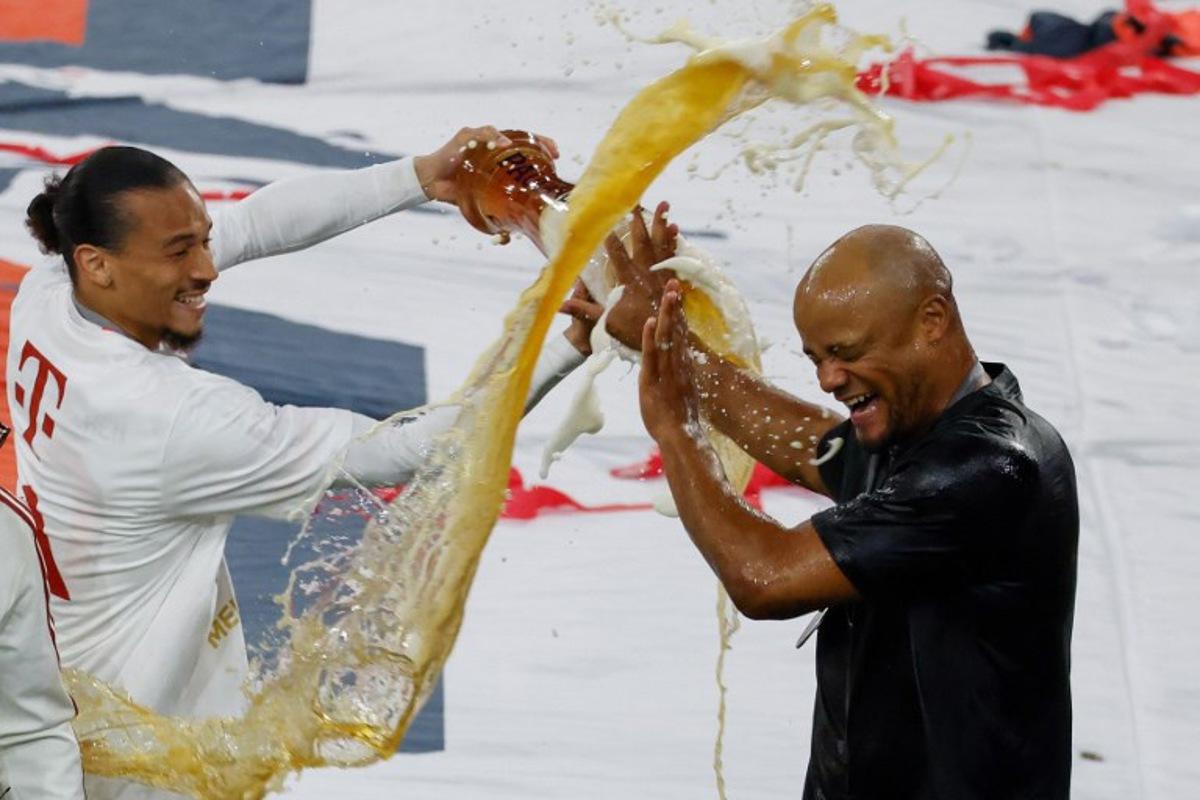 Bayern Munich's German forward #10 Leroy Sane pours beer over Bayern Munich's Belgian head coach Vincent Kompany after the German first division Bundesliga football match between Bayern Munich and Borussia Moenchengladbach in Munich on May 10, 2025. Michaela STACHE / AFP