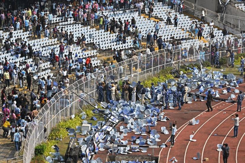 Fans throw chairs as Inter Miami's Argentine forward #10 Lionel Messi departs from the Salt Lake Stadium in Kolkata on December 13, 2025. Thousands of fans packed into a stadium in eastern India on December 13 to cheer on Lionel Messi as the football legend unveiled a 21-metre (70-foot) statue of himself. Dibyangshu SARKAR / AFP