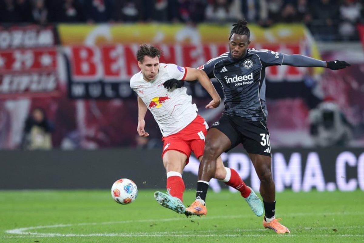 Leipzig's Hungarian defender #04 Willi Orban (L) and Frankfurt's Belgian forward #30 Michy Batshuayi vie for the ball during the German first division Bundesliga football match between RB Leipzig and Eintracht Frankfurt in Leipzig, eastern Germany, on December 6, 2025. Ronny HARTMANN / AFP