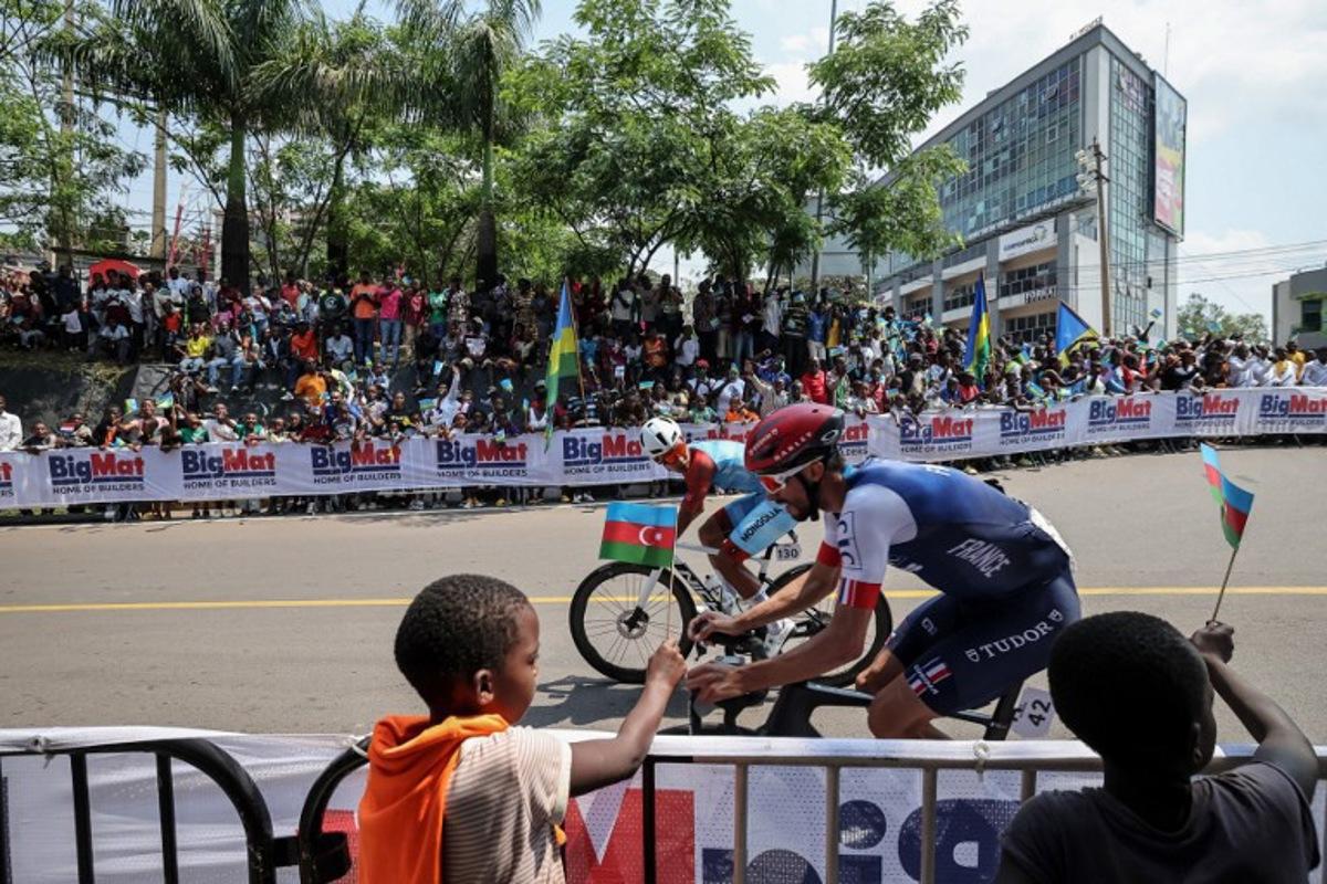 Mongolian rider Tegshbayar Batsaikhan (L) and French rider Julian Alaphilippe (R) competes in the men's Elite road race cycling event during the UCI 2025 Road World Championships, in Kigali, on September 28, 2025. Anne-Christine POUJOULAT / AFP