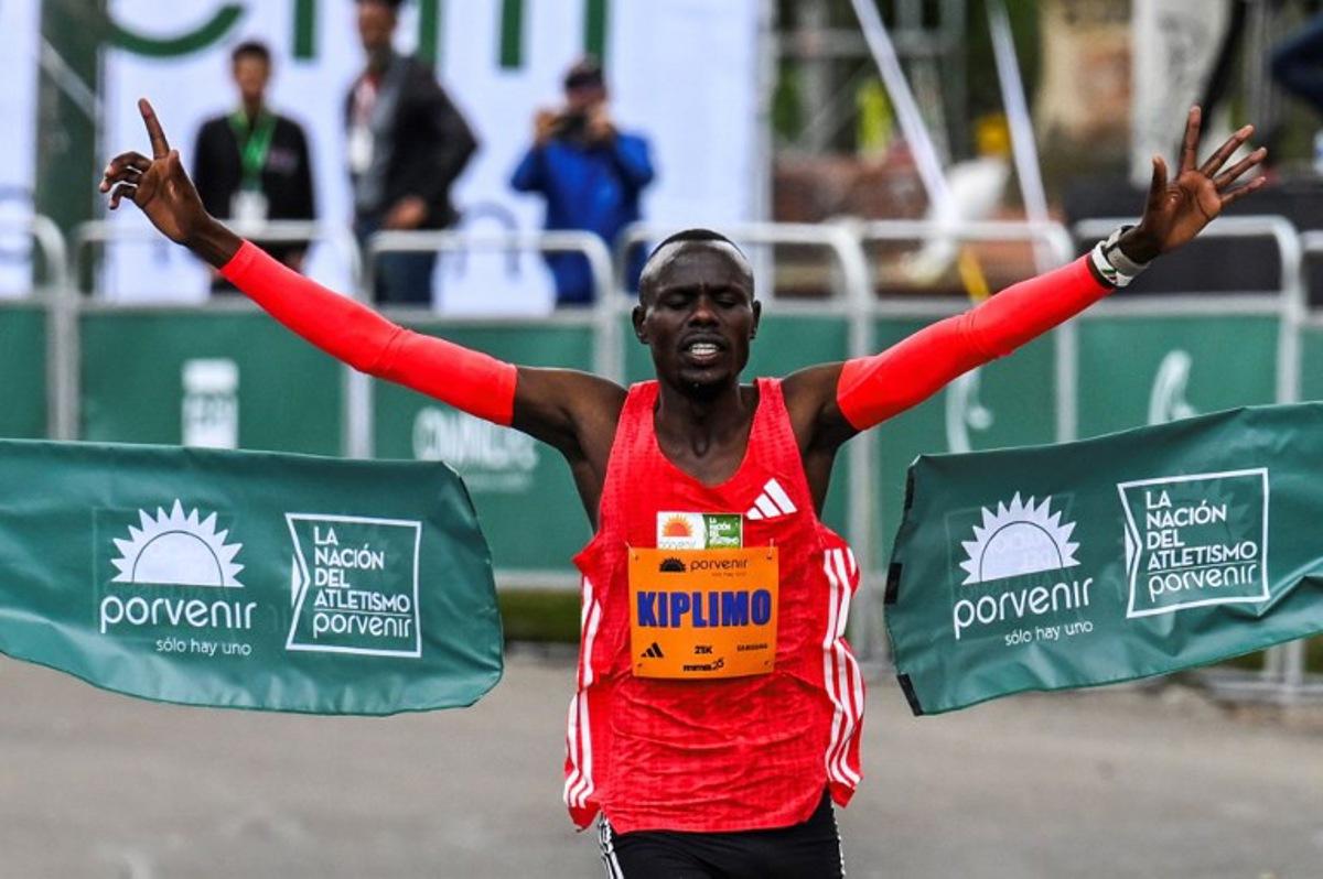 Kenya's Philemon Kiplimo celebrates as he crosses the finish line to win the elite male 21K of the Bogota Half Marathon in Bogota on July 27, 2025. Luis ACOSTA / AFP