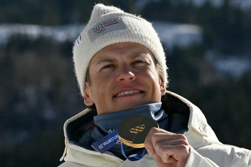 Gold medallist Norway's Johannes Hoesflot Klaebo celebrates on the podium for the men's team cross country free sprint final event of the Milano Cortina 2026 Winter Olympic Games at Tesero Cross-Country Skiing Stadium in Lago di Tesero (Val di Fiemme), on February 18, 2026. Javier SORIANO / AFP