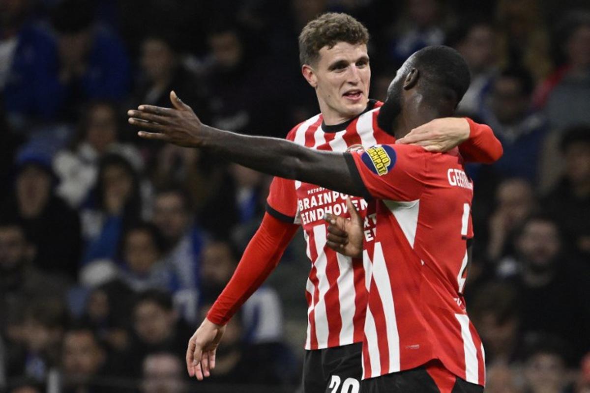 PSV Eindhoven's Dutch midfielder #20 Guus Til (L) celebrates with PSV Eindhoven's Dutch defender #02 Lutsharel Geertruida after scoring the opening goal during the UEFA Champions League first round day 3 football match between FC Porto and PSV Eindhoven at Dragao stadium in Porto, on October 20, 2026 Miguel RIOPA / AFP