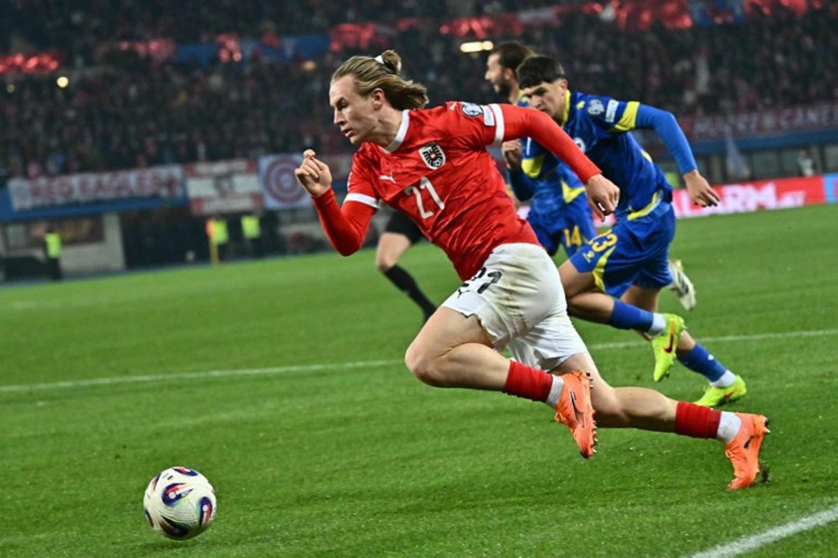 Austria's midfielder #21 Patrick Wimmer and Bosnia-Herzegovina's defender #23 Arjan Malic vie for the ball during the FIFA World Cup 2026 European qualification Group H football match between Austria and Bosnia and Herzegovina, in Vienna on November 18, 2025. Joe Klamar / AFP