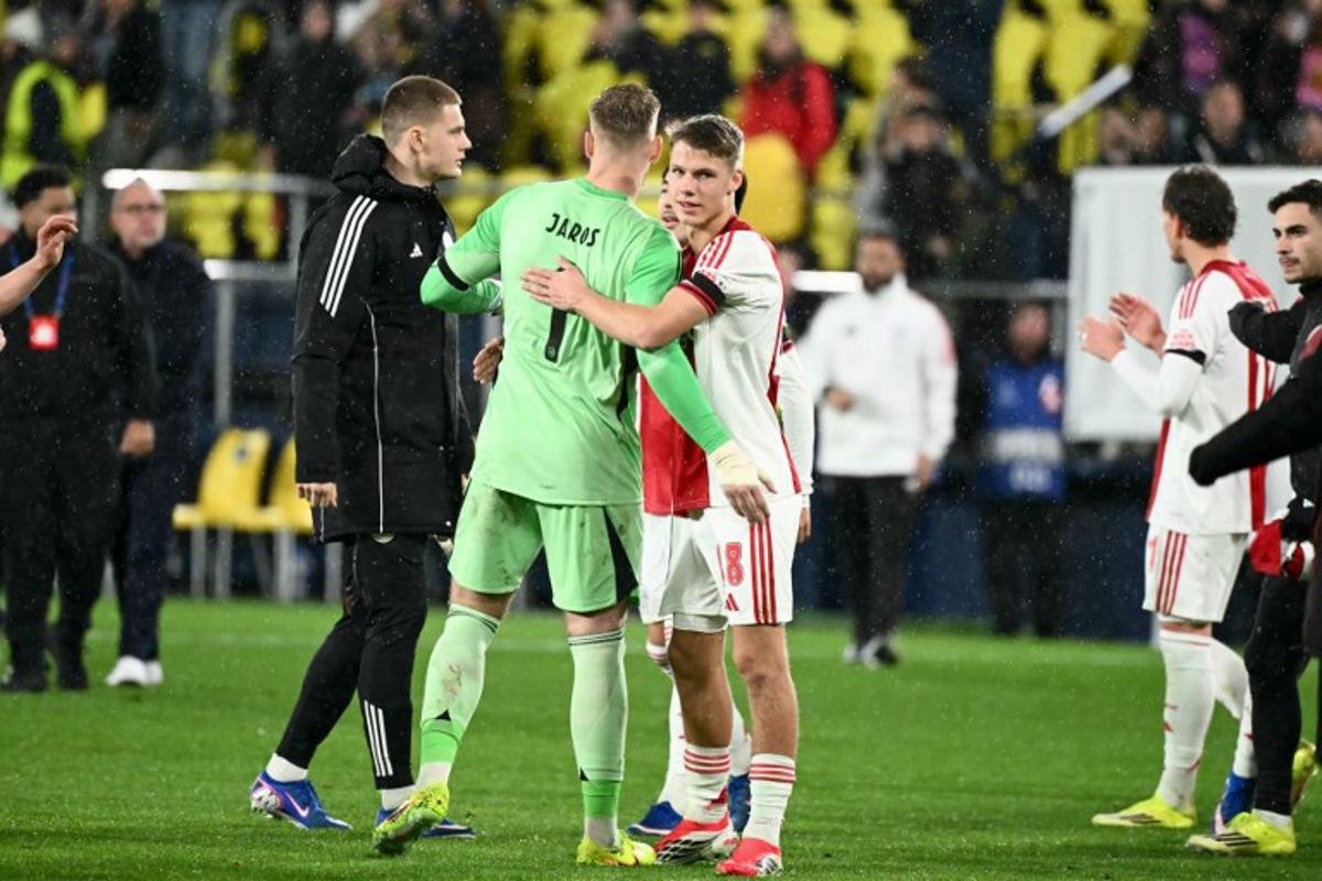 Ajax's Czech goalkeeper #01 Vitezslav Jaros and Dutch midfielder #18 Davy Klaassen celebrate after winning the UEFA Champions League league phase day 7 football match between Villarreal CF and Ajax at La Ceramica Stadium in Vila-real on January 20, 2026. JOSE JORDAN / AFP