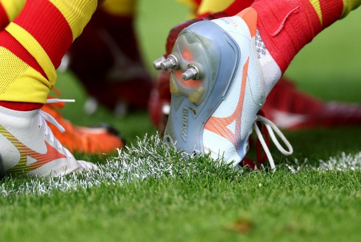 This photograph shows shoe studs on the pitch as Perpignan's players warm up ahead of the French Top14 rugby union match between Racing 92 and Perpignan (USAP) at Stade Dominique-Duvauchelle in Creteil, on the outskirts of Paris, on October 3, 2026. FRANCK FIFE / AFP