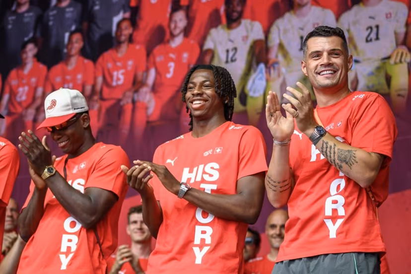 (From L) Switzerland's players forward #07 Breel Embolo, midfielder #09 Johan Manzambi and midfielder #10 Granit Xhaka applaud during a fan reception welcoming the team back to the country following its 2026 FIFA World Cup quarter-final match against Argentina, in Zurich on July 14, 2026. Fabrice COFFRINI / AFP