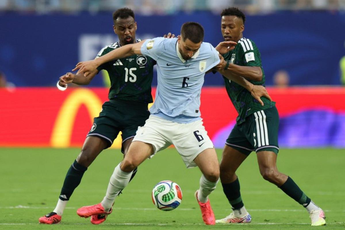 Saudi Arabia's midfielders #15 Abdullah Al-Khaibari, #06 Nasser Al-Dawsari (R) and Uruguay's midfielder #06 Rodrigo Bentancur fight for the ball during the 2026 World Cup Group H football match between Saudi Arabia and Uruguay at the Miami Stadium in Miami Gardens on June 15, 2026. PATRICIA DE MELO MOREIRA / AFP