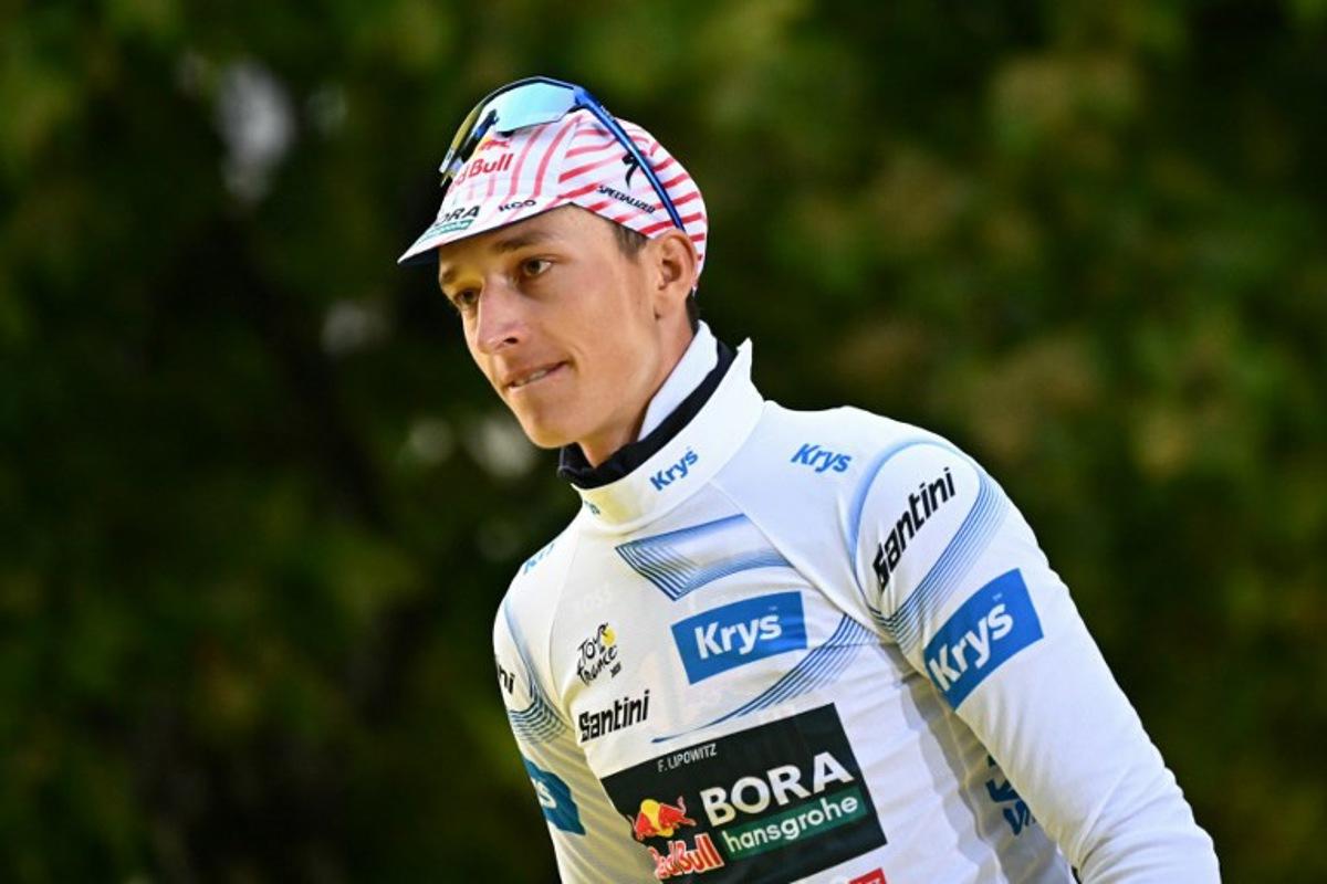 Red Bull - BORA - hansgrohe team's German rider Florian Lipowitz celebrates on the podium with the best young rider's white jersey after the 21st and final stage of the 112th edition of the Tour de France cycling race, 132.3 km between Mantes-la-Ville and Paris Champs-Élysees, on July 27, 2025. Loic VENANCE / AFP